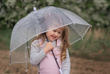 girl is standing under an umbrella in the rain and smiling 