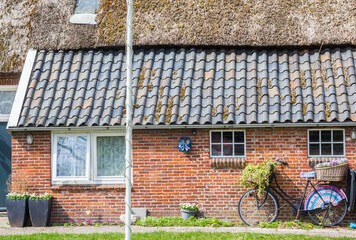 Decorated bicycle with basket and flowers in front of a house in Westervelde, Netherlands