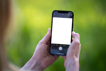 Elderly woman hands takes photos on a new phone with blank screen