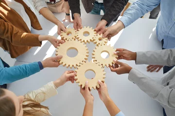 Deurstickers Hands close-up of group multiethnic business people connect wooden gears in the center. Arial view. Success cooperation teamwork concept, connection technology concept © Studio Romantic