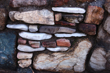 Natural stones of different colors in a decorative fence