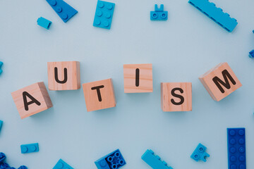 Blue puzzle and wooden blocks with AUTISM word. Close-up. World autism awareness day concept