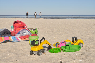 colorful toys for playing in the sand are lying on the beach of the North Sea