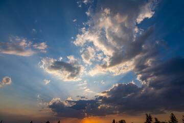 sunset on clouds. Dramatic sunset sky landscape with puffy clouds lit by orange setting sun and blue heavens. sky background