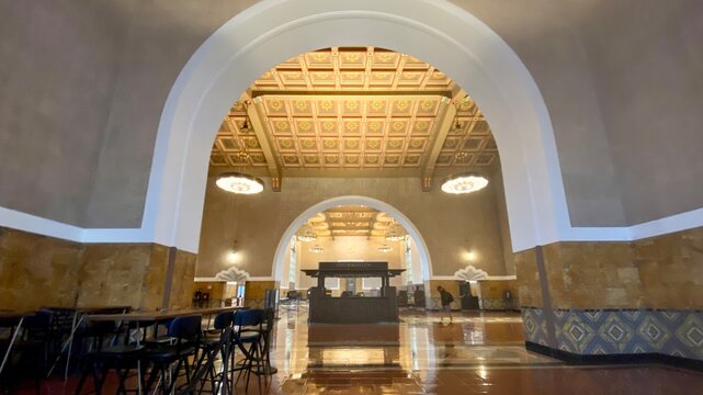 LOS ANGELES, CA, SEP 2021: wide view of information kiosk framed by foreground archway at Union Station in Downtown, with decorative ceiling overhead