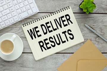 We deliver Results text on an open notepad on an envelope near the keyboard