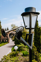 An ancient bronze, metal lantern sculpture of a trumpeter - a musician stands in a city park....