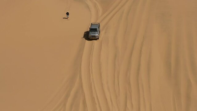 Top view of man taking photos of car that driving in the desert