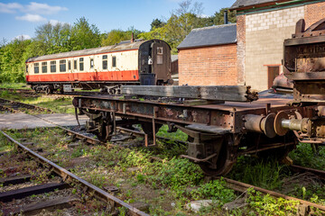 Obraz premium old and abandoned railway carriages and rail industry equipment in a disused railway yard