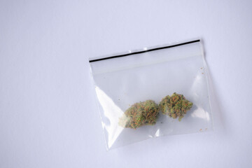 Selective focus two lump of dried hemp in plastic bag, Marijuana on white background, Cannabis is a psychoactive drug from the Cannabis plant used primarily for medical or recreational purposes.