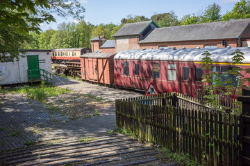 old and abandoned railway carriages and rail industry equipment in a disused railway yard