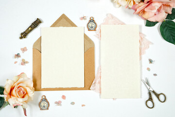 Vintage Theme Wedding Stationery Suite Mockup. Styled with handcrafted paper, blush pink vintage accessories, and natural Kraft paper envelopes. 5 x 7 Invitation and wedding program cards.