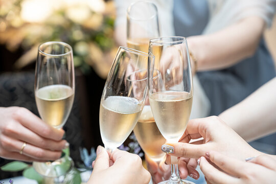 Hands of five women toasting champagne