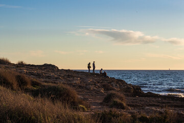 Boys watching the Mediterranean sea at the coast in Palma de Majorca near Coll den Rabassa