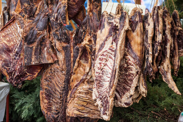 Selective blur on blocks of pork meat, dried cured pork, smoked, hung on a stand in the countryside of serbia. Also called suvomeso, it's a traditional meat product from balkans...