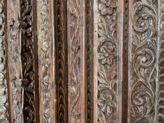 close-up of old, carved, detailed wood in vertical columns. Dark hardwood Asian or Middle Eastern Design