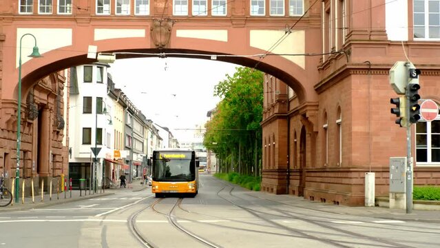 Darmstadt, Germany - May 2022: electric buses and trams go along main sight of city, tourists and citizens walk, concept of historical, modern public transport of European cities, urban tourism