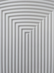 White, rounded, ridges form dimensional concentric rectangles which are arched at the top. Abstract background texture looks art deco. All white with gray shadows forming dimension. 