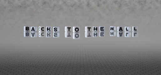 backs to the wall word or concept represented by black and white letter cubes on a grey horizon...