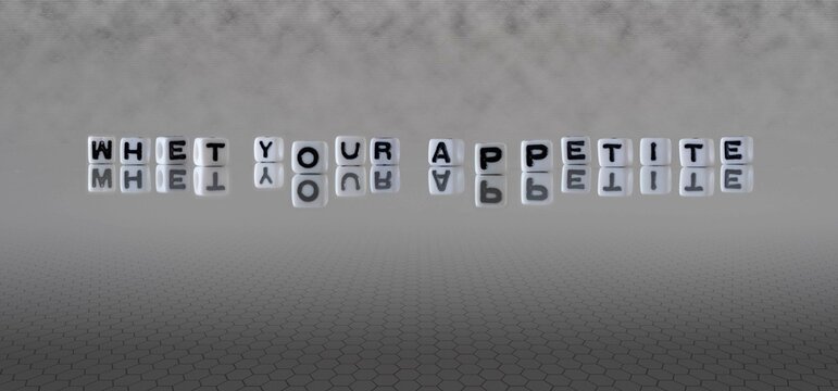 whet your appetite word or concept represented by black and white letter cubes on a grey horizon background stretching to infinity