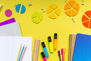 Multicolored fractions, rulers, pencils, notepad on yellow background. Interesting, fun math for...