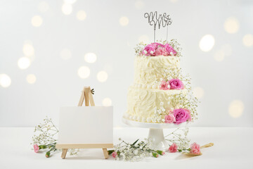 Wedding 2 Tiered Cake with Mr and Mrs topper. Styled with fresh pink roses and gypsophila flowers,...