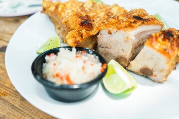 45 degree photo of a plate with lime fried pork shoulder and spicy onion salad. Traditional Latin American dish.