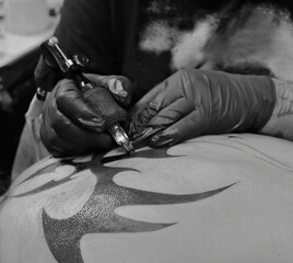 Tatuador en sesión de tatuaje tatuando un tatuaje a una persona