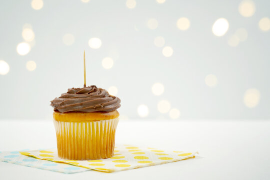 Chocolate Cupcake Topper Mockup. Styled against a white background with bokeh party fairy lights. Copy space for your design here.
