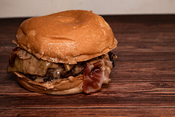 Top view of a hamburger on a dark wood table. Beef burger. Space for text.
