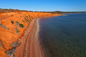 Aerial drone landscape view of coastal sea shore red cliffs and turquoise water