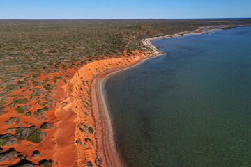 Aerial drone landscape view of coastal sea shore red cliffs and turquoise water