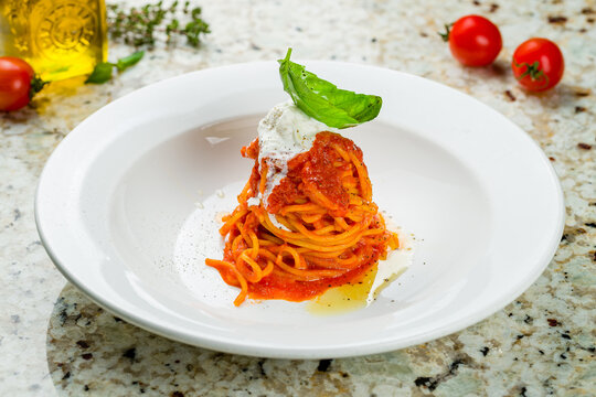 Pomodoro spaghetti in white plate with strachatella cheese