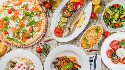 Pizza with salmon, aragula, parmesan, fried seabass with vegetables,salad buratta with tomatoes, vegetable salad , black pasta with shrimps, lasagna bolognese top view on marble table