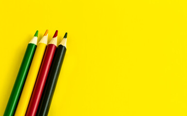 colored pencil placed on yellow paper background with copy space for your image or text. High-quality photo