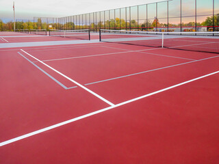 New red tennis court with white lines combined with gray pickleball lines