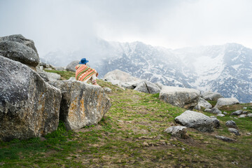 Person on the top of the mountain in Triund Trek, Himachal Pradesh, India.
