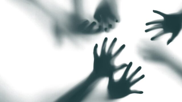 Silhouette of a zombie hand on white background in slow motion
