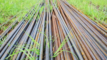 A pile of rusty rebar on the ground. Horizontal background of deformed bars and rebar at a...