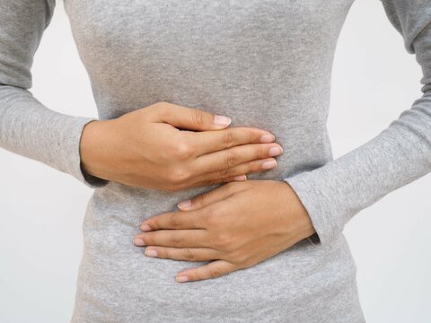 Woman with stomach pain causes of abdominal pain include inflammatory bowel disease-IBD. stomach ulcer irritable bowel syndrome (IBS), ulcerative colitis and microvilli. closeup photo, blurred.