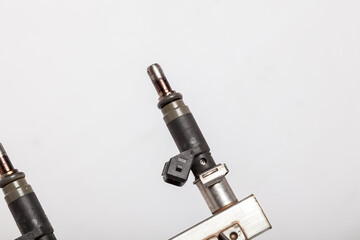 Close-up on a car fuel injector for supplying gasoline to cylinder engine on a white isolated background. Spare parts catalog