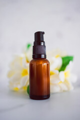 natural beauty and organic ingredients in skincare, apothecary skincare bottle with tropical flowers bokeh