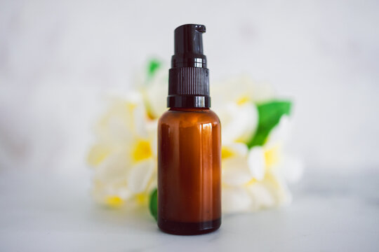natural beauty and organic ingredients in skincare, apothecary skincare bottle with tropical flowers bokeh