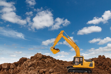 Excavator  are digging  soil in the construction site on sky  background,with white fluffy cloud