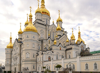 Fototapeta na wymiar Religious buildings. Pochayiv, Ukraine, 2021, may - orthodox church with golden domes, Trinity cathedral and bell tower in Pochaev Lavra