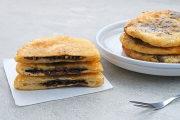 Hotteok, South Korean pancakes or fried dough with nuts and sugar filling, traditional street food. Selected focus.
