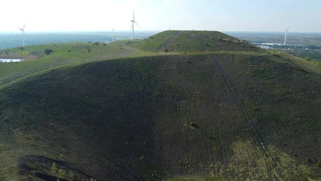 High Mining Heap With Wind Turbine Farm Behind, Aerial Drone View