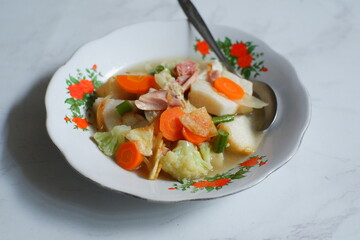 a plate of rice cake served with vegetables soup 