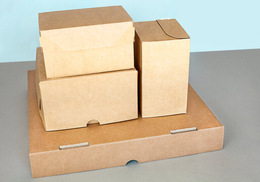 A Stack Of Cardboard Boxes On A Gray Table On A Blue Background. View From Above