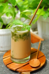 a glass of iced coffee with green grass jelly 